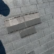 Missing shingle tabs exposing the layer underneath on an asphalt roof