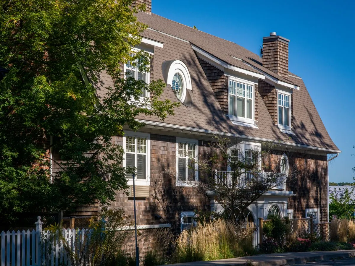 Two-story house with dormers, a chimney and a shingle roof