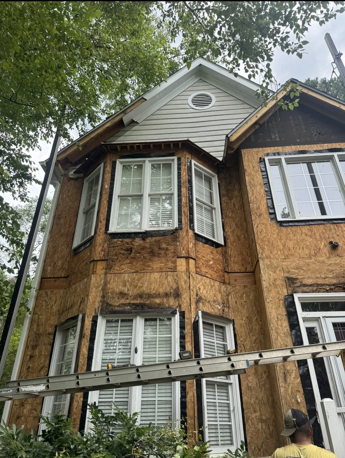 Exposed wall sheathing on a two-story home with bay windows