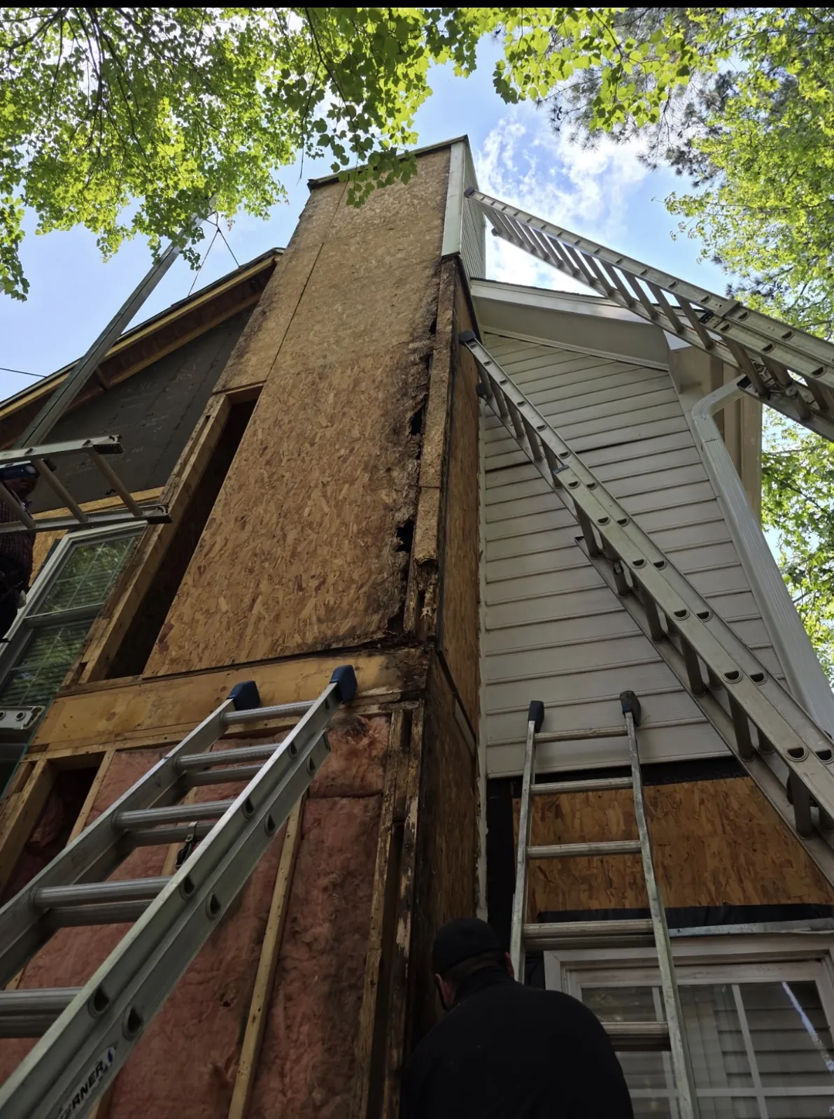 Wall sheathing and ladders on the side of a two-story home
