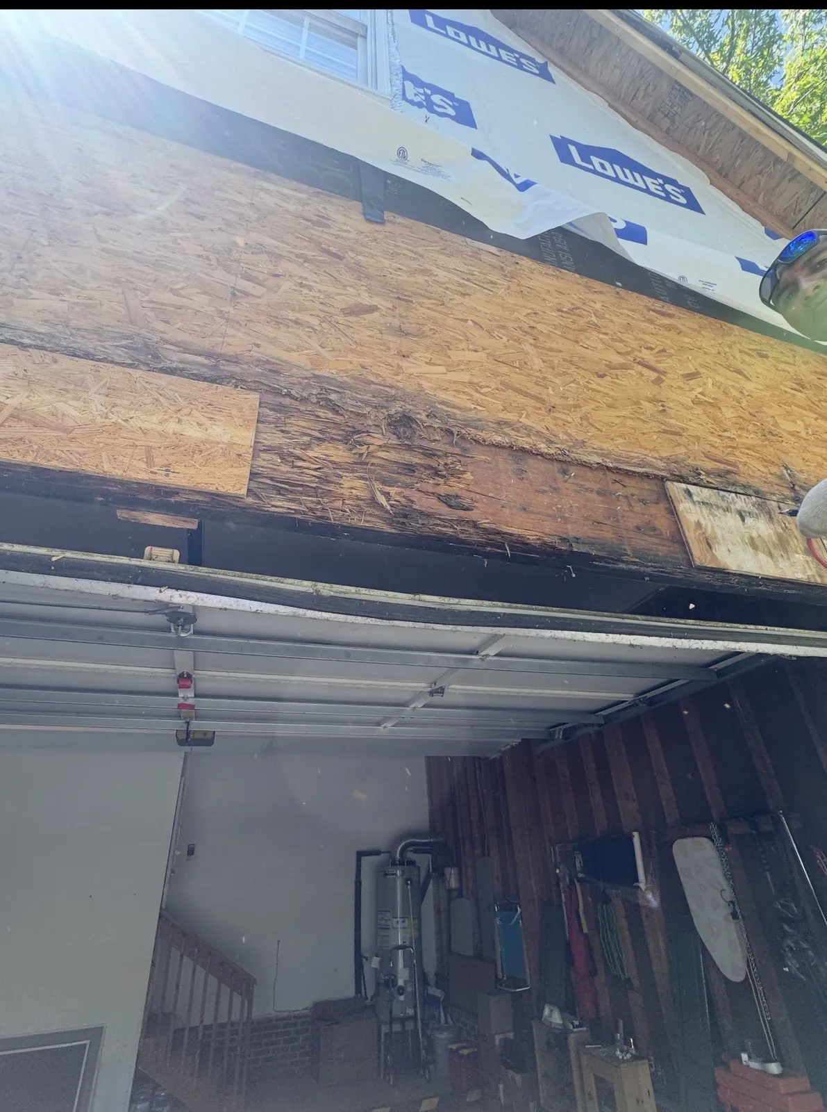 Rotted sheathing above a garage door opening