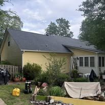 Dark shingle roof on a yellow ranch home