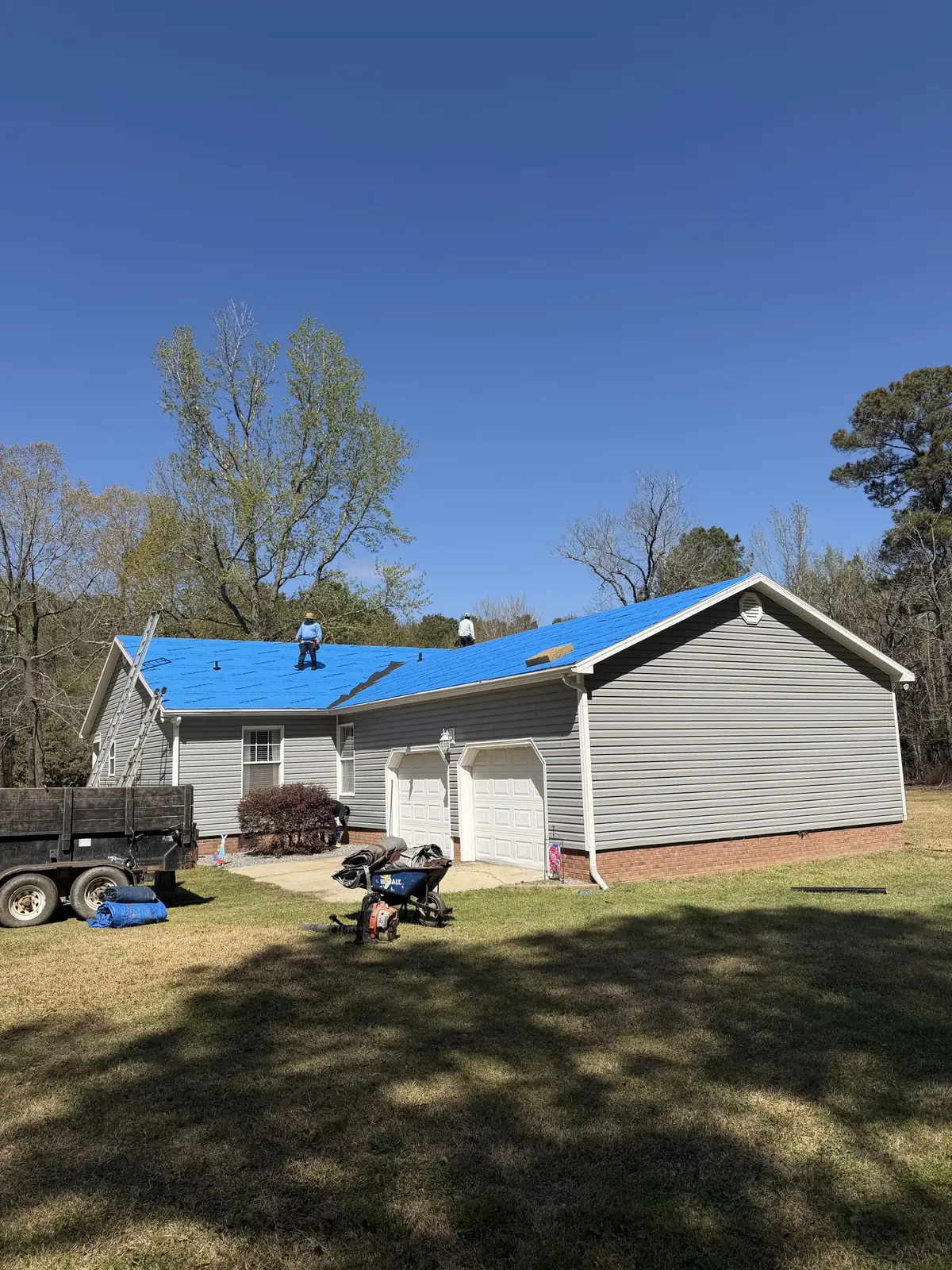 Garage side of a one-story home with a work trailer