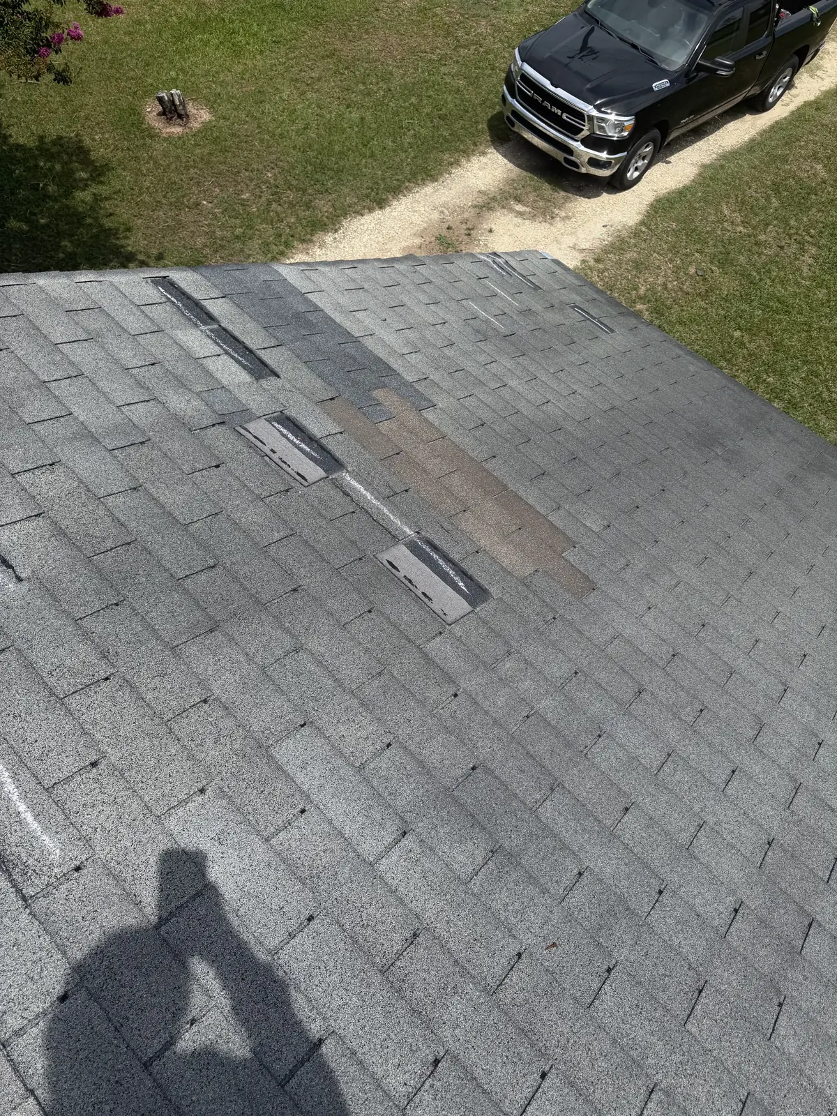 Close-up of lifted and creased asphalt shingle tabs on a damaged roof