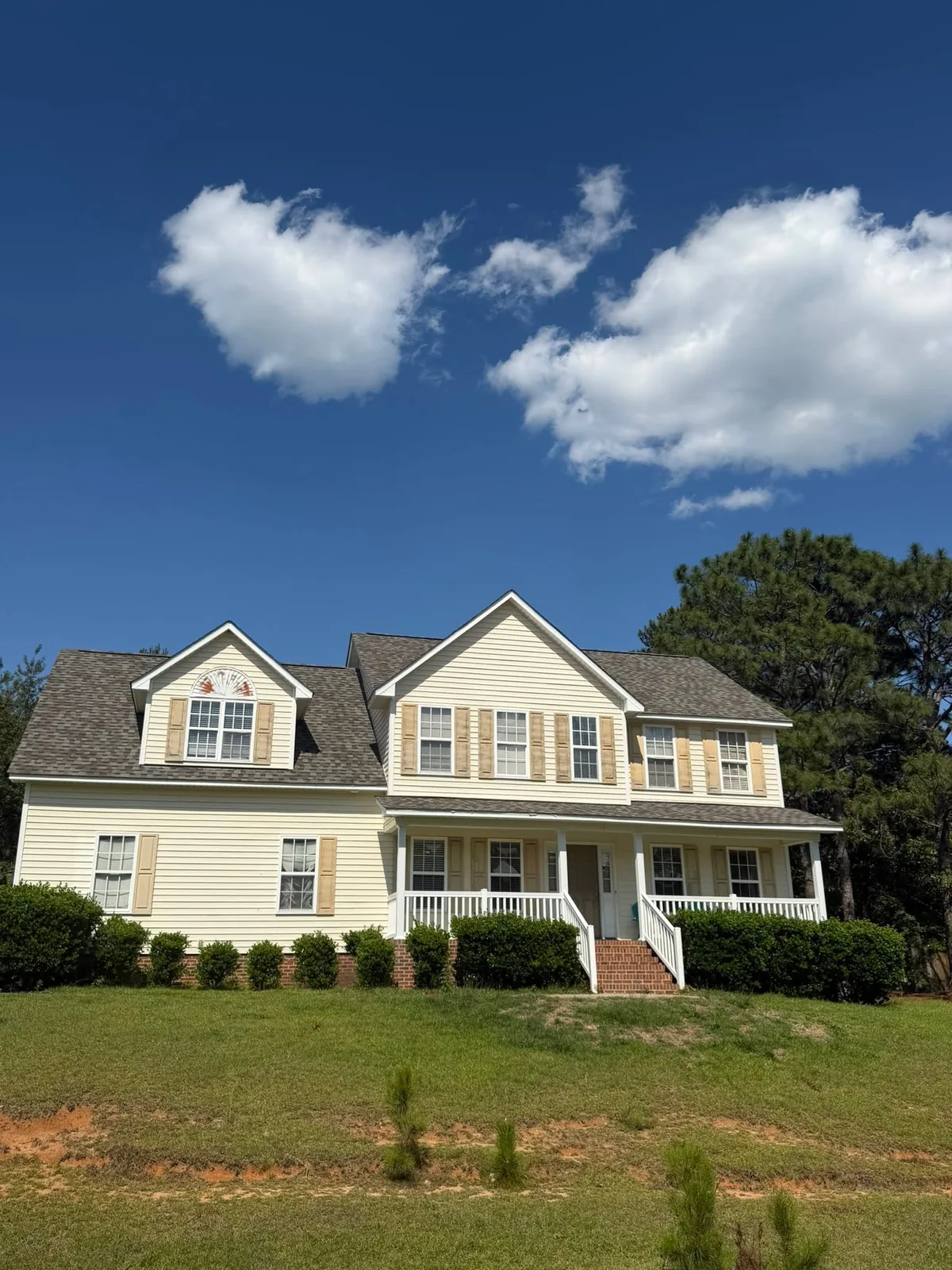 Two-story home with a front porch and a gray shingle roof